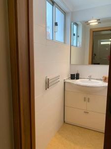 a bathroom with a sink and a mirror at Cozy family apartment in Cascais in Cascais