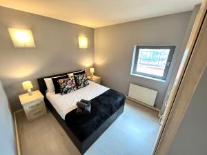 a bedroom with a bed and two lamps and a window at Stunning 1 Bed flat in Canary Wharf FREE parking in London