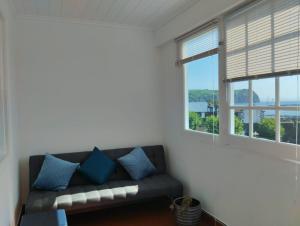 uma sala de estar com um sofá e duas janelas em SEASTAR nº36 em Horta