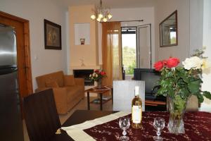 ein Wohnzimmer mit einem Tisch und einer Flasche Wein in der Unterkunft villa Nefeli in Lambiní