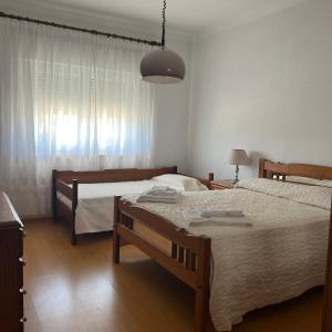 1 dormitorio con 2 camas individuales y lámpara en Alojamento das Laranjeiras, en Fernao Ferro
