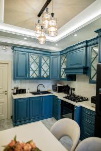 uma cozinha azul com armários azuis e um lavatório em Comfy Home em Yerevan