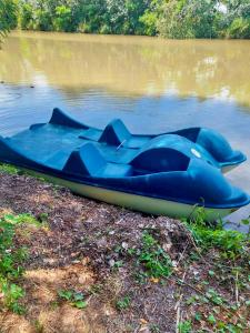 een blauwe boot aan de kant van het water bij Hacienda Verde in Szentes