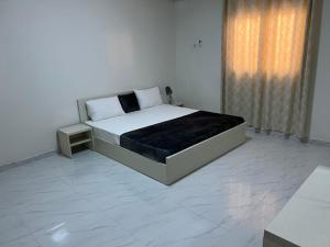 a white bedroom with a large bed and a window at 1704 A&D Tevragh Zeina in Nouakchott