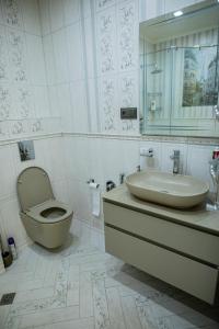 uma casa de banho com um lavatório, um WC e um espelho. em Comfy Home em Yerevan