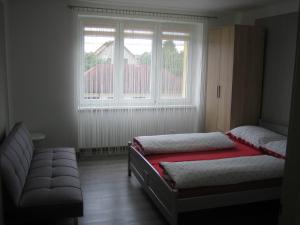 een slaapkamer met 2 bedden en een raam bij Apartmány Polepy in Polepy