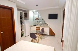 a kitchen with a table and chairs and a staircase at Flat da Eliete e Admilson 2 in Porto Seguro