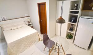 um quarto com uma cama, uma mesa e uma cadeira em Flat da Eliete e Admilson 2 em Porto Seguro
