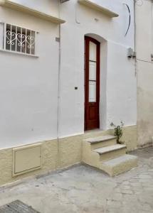 a white building with a red door and stairs at Casa Noal in Nardò
