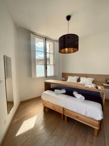 1 dormitorio con cama y ventana grande en Mieuxqualhotel jacuzzi privatif Le rond en Burdeos