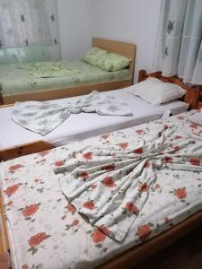 two beds in a room with flowers on them at Casa Tinu in Cenad