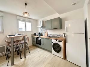 une cuisine avec un réfrigérateur blanc et une table dans l'établissement Les Forgerons - Chaleureux - Central, à Mont-de-Marsan