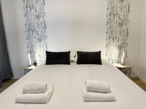 1 cama blanca grande con 2 almohadas en LES FORGERONS - Chaleureux, en Mont-de-Marsan