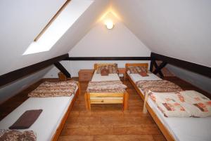 a attic room with three beds and a window at Noclegi Dorotowo in Dorotowo