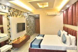 a hotel room with a bed and a tv at City Square in Deoghar