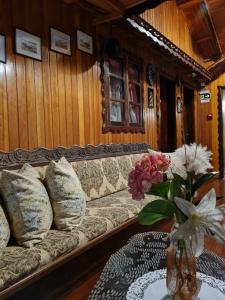 uma sala de estar com um sofá e uma mesa com flores em Hotel Schneider em Treze Tílias