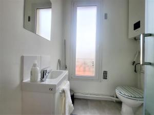 a white bathroom with a sink and a toilet at L'Oasis - Charmant appartement Métro Porte d'Italie in Le Kremlin-Bicêtre