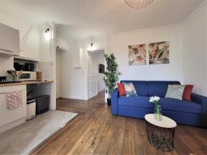 萊克朗蘭比塞特爾的住宿－L'Oasis - Charmant appartement Métro Porte d'Italie，客厅配有蓝色的沙发和桌子