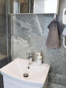 een badkamer met een witte wastafel en een douche bij OniksApart A190 in Warschau