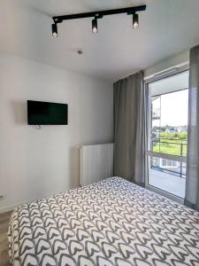 een slaapkamer met een bed en een groot raam bij OniksApart A190 in Warschau