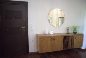 a bathroom with a mirror and a wooden dresser at Kouros At The Park in Alexandroupoli