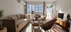 a living room with a couch and a table and chairs at Lavadeira's House in Olhão