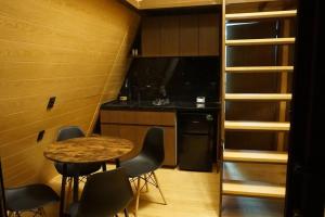 una pequeña cocina con mesa y sillas en una habitación en Cabaña A-Frame en La Estanzuela, en Estanzuela