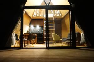 Habitación con ventana grande, mesa y sillas. en Cabaña A-Frame en La Estanzuela, en Estanzuela