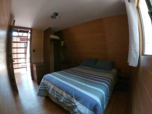 1 dormitorio con 1 cama en una habitación con ventana en Cabaña A-Frame en La Estanzuela, en Estanzuela