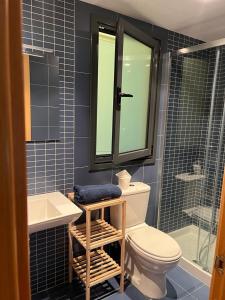 a bathroom with a toilet and a sink and a shower at El Ñeru'l Cantu in Villaviciosa