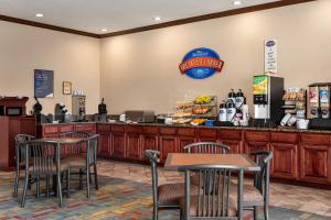 a restaurant with tables and chairs and a counter at Baymont by Wyndham Wichita Falls in Wichita Falls