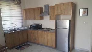 a kitchen with wooden cabinets and a refrigerator at Aida's Home-Shmeisani central location near Abdali in Amman