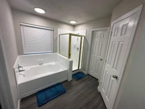 La salle de bains est pourvue d'une baignoire, d'un lavabo et d'un miroir. dans l'établissement Entire Home in Lewisville hosted by Mesonn, à Lewisville