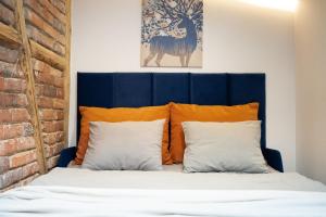 een bed met een blauw hoofdeinde en 2 kussens bij BEDTHOVEN Self Check in in Tychy