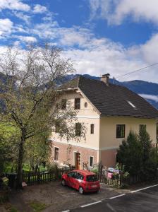 a red car parked in front of a house at Ferienwohnungen Rosi in Kleblach