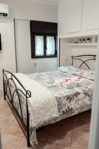 a bedroom with a bed with pinkippers on it at Casetta 46 in Ostia Antica