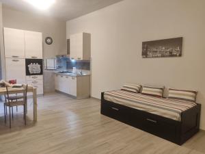a bedroom with a bed and a table and a kitchen at La Girandola in Grosseto