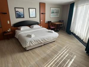 a bedroom with a large bed and a table at Hotel EUROPACITY in Brussels