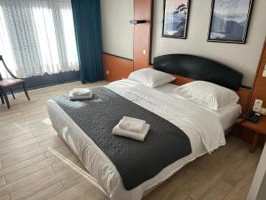 1 dormitorio con 1 cama grande y 2 toallas. en Hotel EUROPACITY en Bruselas