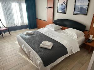 a bedroom with a large bed with two towels on it at Hotel EUROPACITY in Brussels
