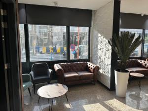 a lobby with couches and chairs and a large window at Hotel EUROPACITY in Brussels