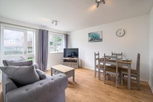 a living room with a couch and a table and a dining room at Crawley Atkinson Pet Friendly 1-Bedroom Apartment in Three Bridges