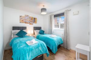 a bedroom with two beds and a window at Crawley Atkinson Pet Friendly 1-Bedroom Apartment in Three Bridges