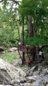 Un groupe de personnes debout sur un pont sur une rivière dans l'établissement Finca Los 3 Laureles Nicaragua AgroEcolodge, à San Ramón