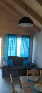 - un salon avec un canapé et des rideaux bleus dans l'établissement Domki Martes Wicie, à Wicie