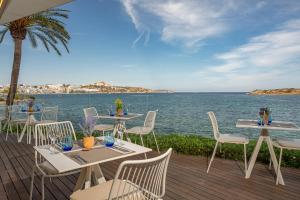 a deck with tables and chairs and the ocean at Hotel Torre del Mar - Ibiza in Playa d'en Bossa