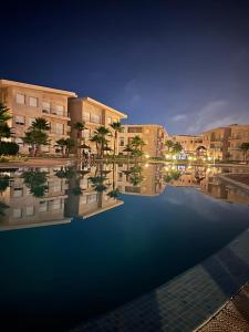 una representación de un edificio con piscina por la noche en Appartement Plage Mehdia - Residence Kenz Mehdya Beach, en Kenitra