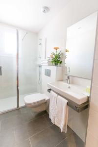 ein weißes Bad mit einem WC und einem Waschbecken in der Unterkunft Hotel Playas de Paguera in Paguera