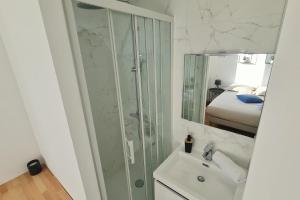 ein weißes Badezimmer mit Dusche und Waschbecken in der Unterkunft Le Jaures 4 - T2 - 1er Etage in Hennebont + 10 Fotos