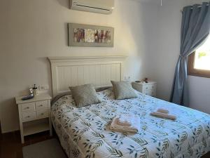 a bedroom with a bed with two towels on it at Entire Bungalow style villa in La Manga Club in Atamaría +30 photos